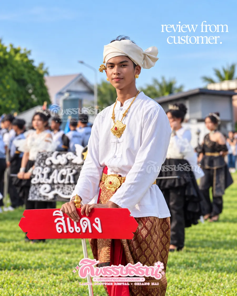 ชายสวมชุดพื้นเมืองสีขาวและผ้าโพกในขบวนกีฬาสี