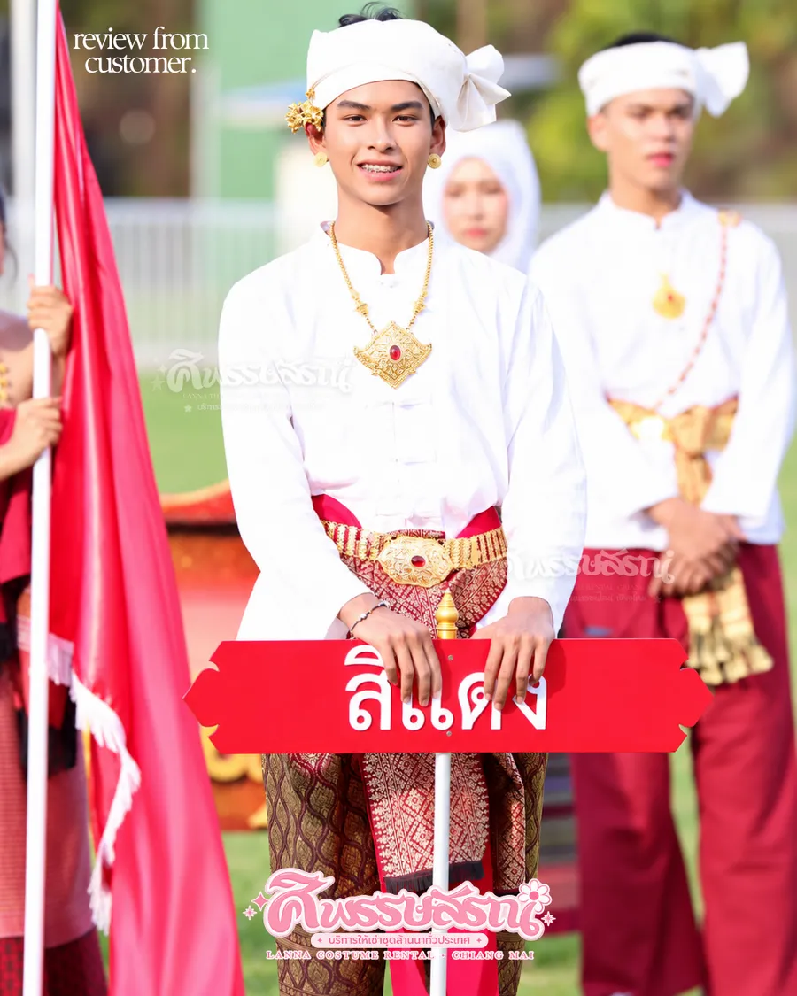 ชายในขบวนกีฬาสีสวมเสื้อสีขาว ผ้าโพกและผ้าคาดเอวโทนแดงทอง